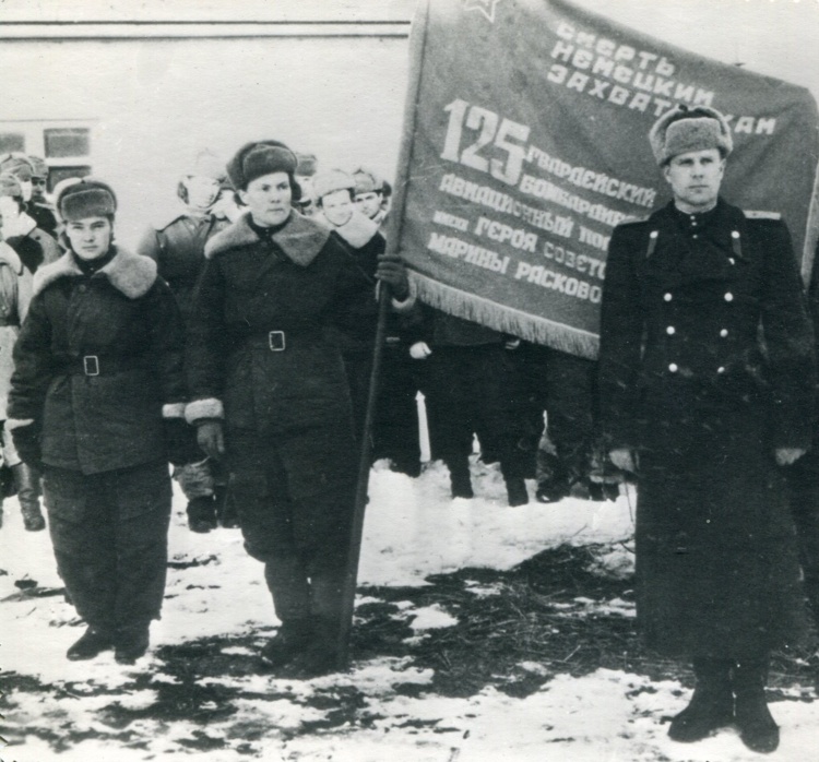 Командир полка подполковник Валентин Васильевич Марков, знаменосец полка — штурман Валентина Кравченко, ассистент знаменосца полка — штурман Антонина Зубкова. 1943/1944. Музеи Рязанской области.